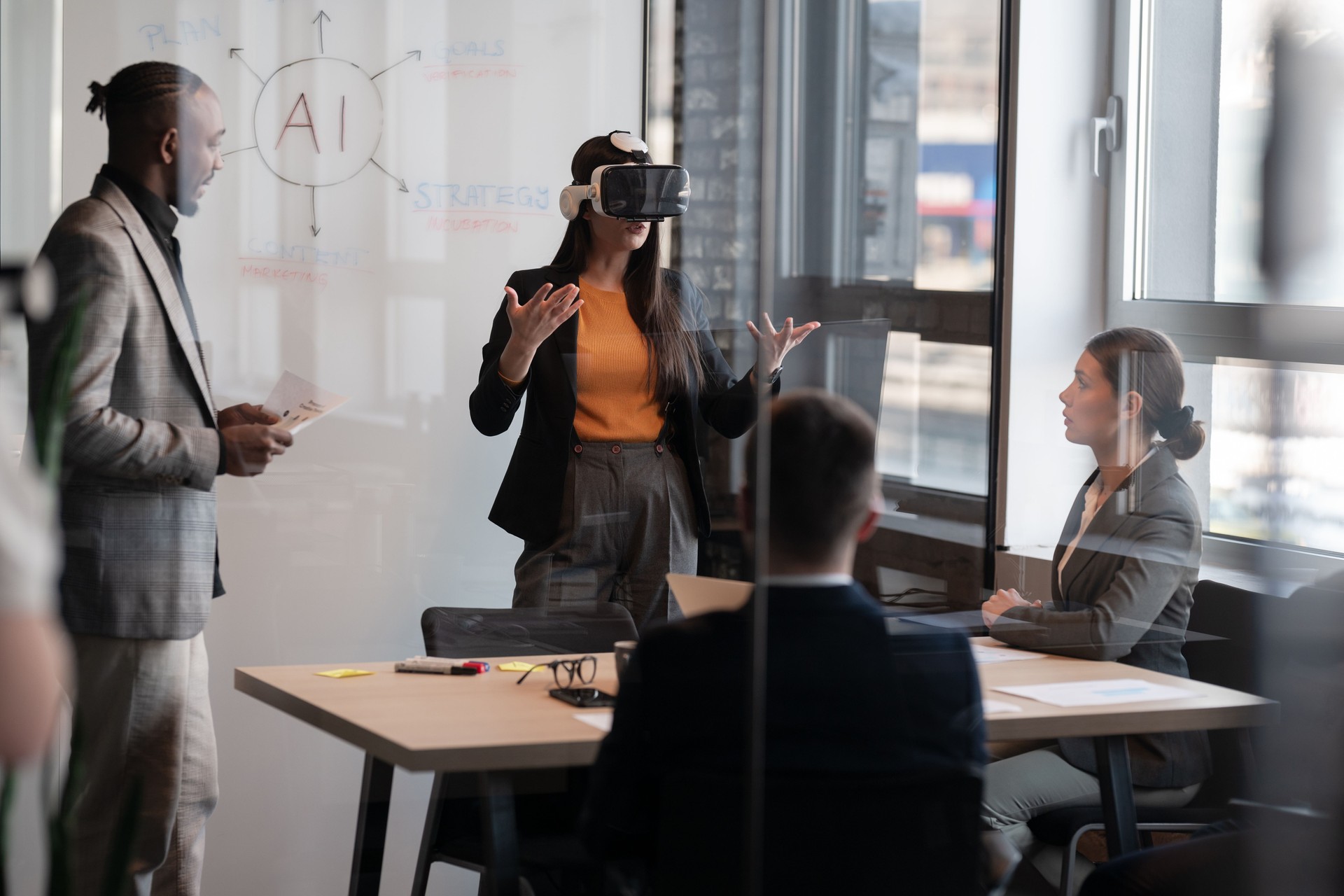 Business professionals in a modern office discussing artificial intelligence. A woman wearing a VR headset presents ideas while colleagues listen. Concept of AI technology in corporate meetings
